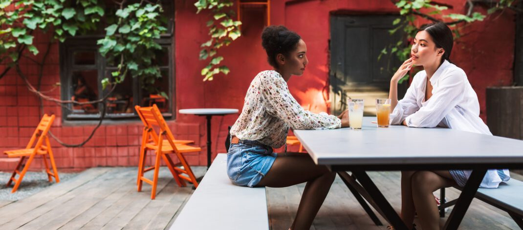 Young beautiful ladies spending time together with cocktails in